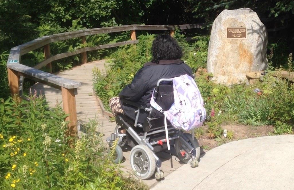 Mobility user entering boardwalk at Wynn Nature Center